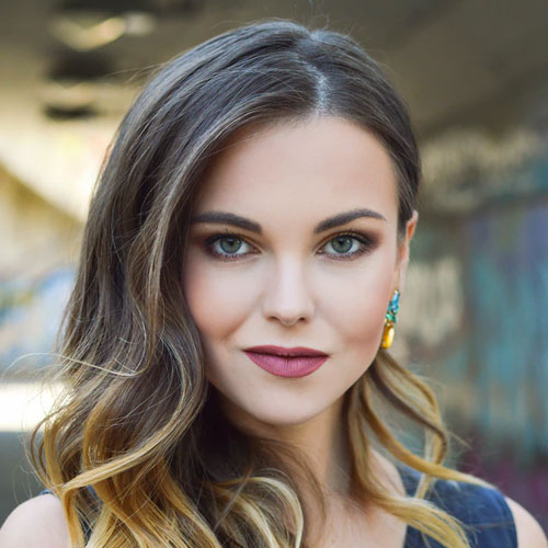 photoshoot of a woman who wears great make-up and hairstyling, earrings and smile